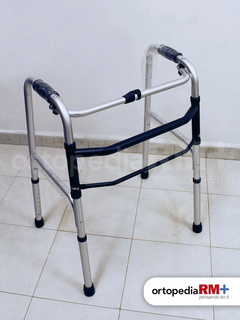 Andadera fija de aluminio anodizado con altura ajustable y puños ergonómicos.